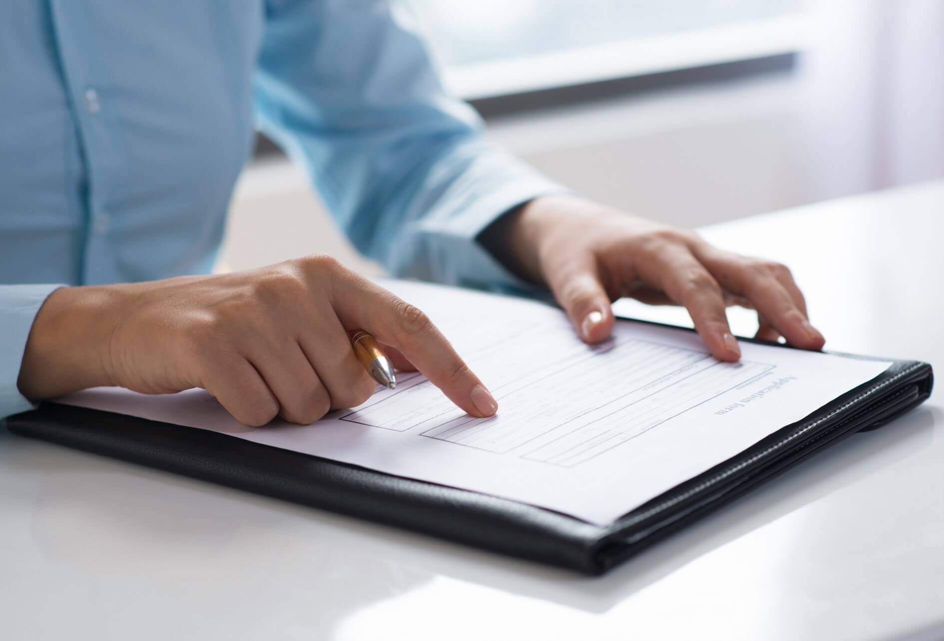 Humain consultant et vérifiant un document administratif et technique sur une table.